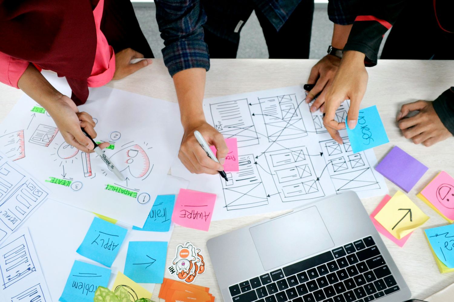 A team sketching product concepts and wireframes across a table